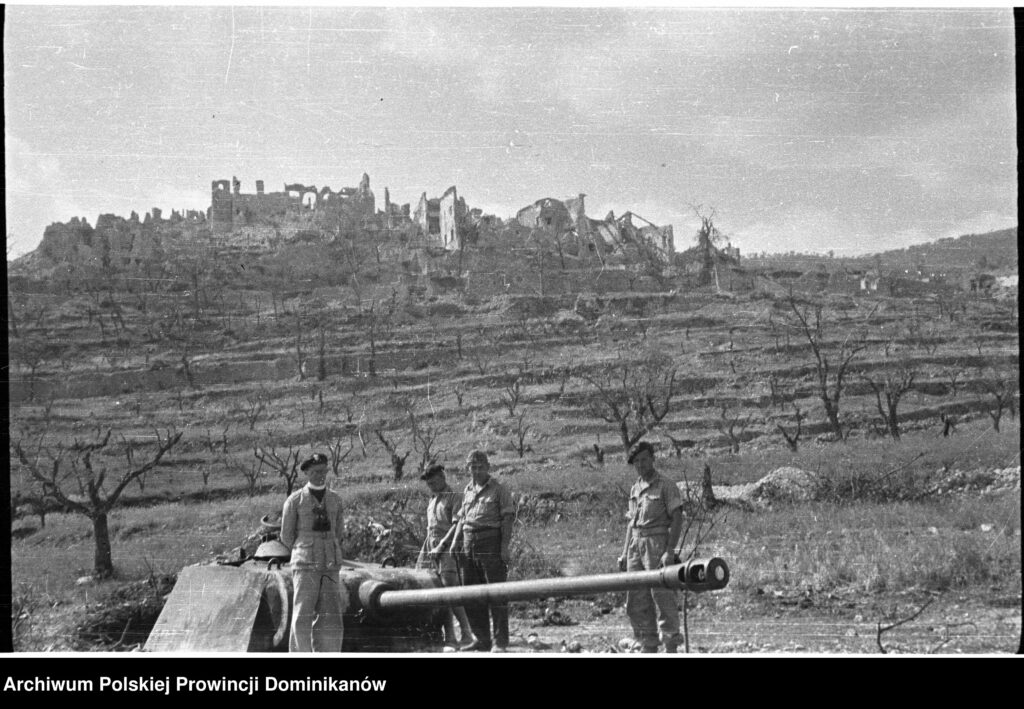 Widok na ruiny Piedimonte San Germano - na pierwszym planie żołnierze obok Pantherturm (bunkra zwieńczonego wieżą czołgu Pantera). Po lewej o. Adam Studziński OP